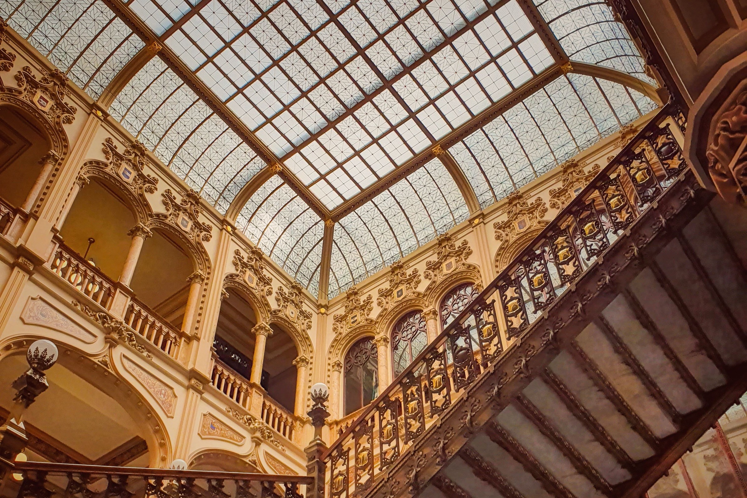 A glass-roofed light well above a stone staircase.